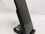 a close up of a cell phone on a stand on a white surface
