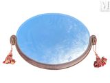 un miroir rond auquel est suspendu un pompon