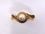a close up of a gold ring with a pearl in it
