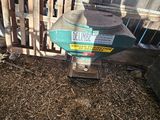 a machine that is sitting on the ground in front of a fence