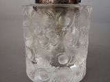 a clear glass jar with a silver lid on a table