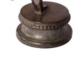 a statue of a woman holding a hat on top of a pedestal