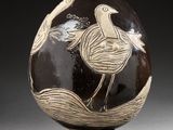 a black and white vase with a bird on it