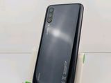 a close up of a cell phone on a stand on a white surface