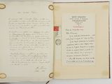 an open book with a handwritten letter on it sitting on a table