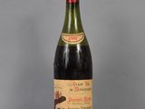 une vieille bouteille de vin posée sur une table en verre
