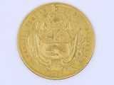 a gold coin on a white surface with a white background