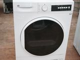 une machine à laver blanche posée à même le sol dans une pièce