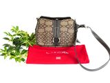 the purse is sitting next to a red bag and a plant