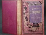 an old book with a pink cover sitting on top of a table
