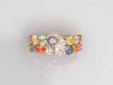 gros plan d'une bague en or avec des pierres multicolores