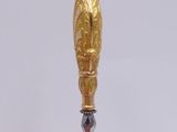 a gold spoon with a wooden handle on a table