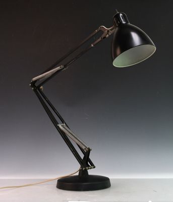 une lampe noire posée sur une table près d'un mur