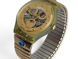 une montre posée sur un bracelet, sur une surface blanche