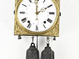 a clock that is hanging on the wall next to a bell