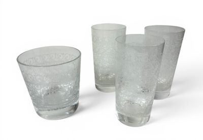 quatre verres posés les uns à côté des autres sur une surface blanche
