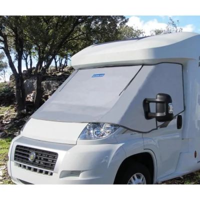 un petit camping-car blanc garé dans l'herbe