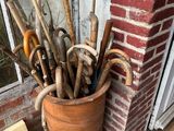 a pot full of old umbrellas on the porch
