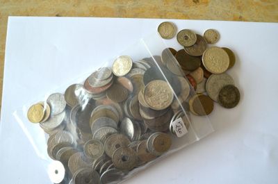 un sac de pièces posé sur une table à côté d'une pile de pièces