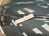 a sticker on the hood of a car that is parked in a parking lot