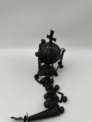 photographie en noir et blanc d'un collier orné d'une croix et d'un poignard