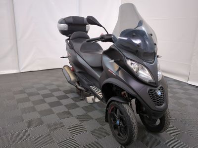 un scooter garé sur un sol à damier