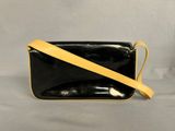 a black and yellow purse sitting on top of a white table