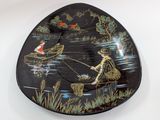 a black plate with a picture of a man fishing