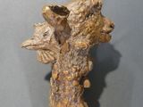 a sculpture of a bear on top of a wooden stick