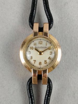 an image of a gold watch with a black leather strap