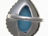 a silver and blue brooch on a white background