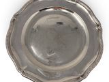 an antique silver plate on a white background with a red handle
