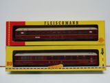 deux wagons rouges et blancs placés côte à côte sur une surface blanche
