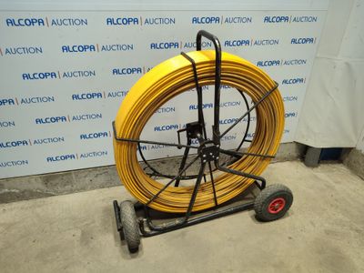 an image of a yellow hose is on a cart in front of a wall