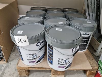 de nombreux seaux de peinture posés sur une palette dans un magasin