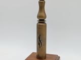 an old brass pepper mill on a wooden base with a white background