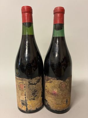 two bottles of wine sitting on top of a table next to each other
