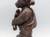 wooden statue of a bear with a hat and holding a pipe