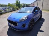 a blue car parked in a parking lot next to a building