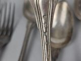 a close up of a silver spoon and a fork on a table