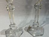 deux bougeoirs en verre transparent posés sur une table blanche