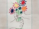 embroidered picture of a hand holding a bouquet of flowers in a vase