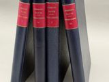 trois livres sont empilés sur une surface blanche