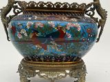a blue vase with a bird on it on a stand