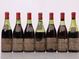 six bouteilles de vin sont alignées sur une table
