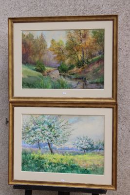 Deux tableaux représentant des arbres sont accrochés au mur d'une pièce.