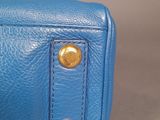 blue leather purse with gold hardware on the front