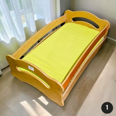un lit en bois recouvert d'un drap jaune