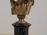 a bronze bust of a man sitting on a table