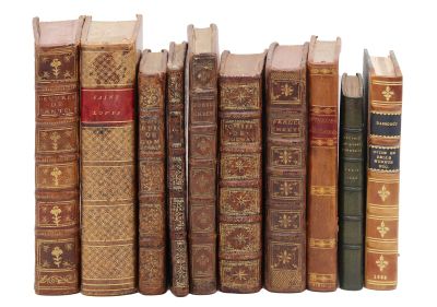 plusieurs vieux livres sont alignés sur une surface blanche